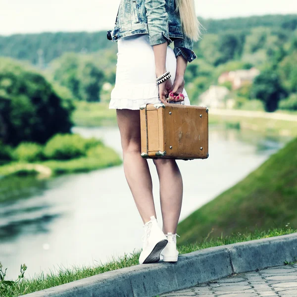 Hipster girl with vintage suitcase on the urban landscape — Stock Photo, Image