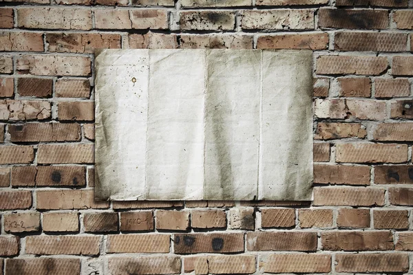 Бумага на кирпичной стене — стоковое фото