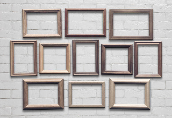 old photo frames on white brick wall