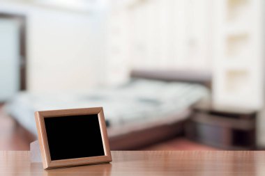 Yatak odasındaki ahşap masada fotoğraf çerçevesi.