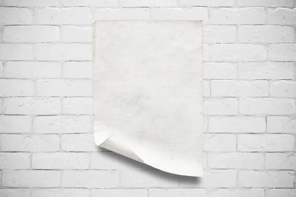 白いレンガの壁に古い紙 — ストック写真