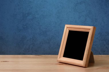 Masada ahşap fotoğraf çerçevesi, mavi duvar.