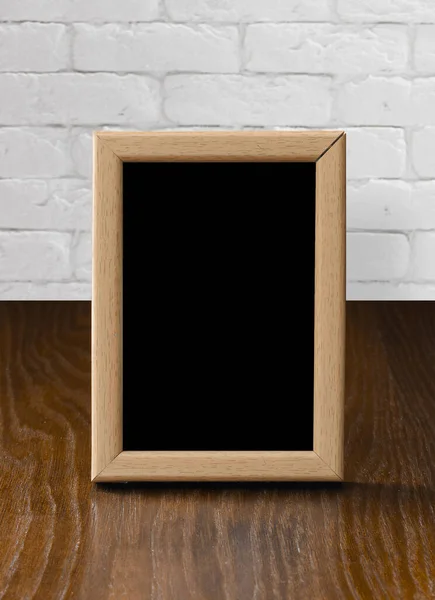 Oud Fotolijstje Houten Tafel Witte Bakstenen Muur — Stockfoto