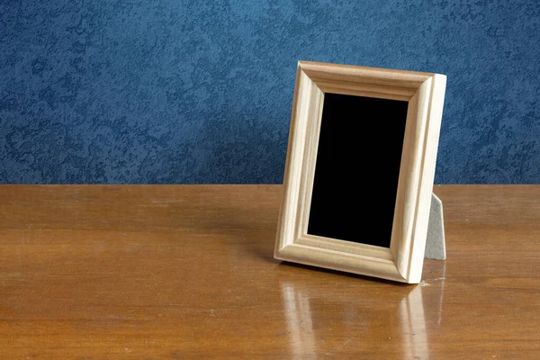 桌子上的木制相框 蓝色墙壁 — 图库照片