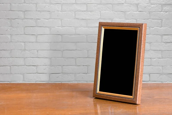 Oud Fotolijstje Houten Tafel Witte Bakstenen Muur — Stockfoto