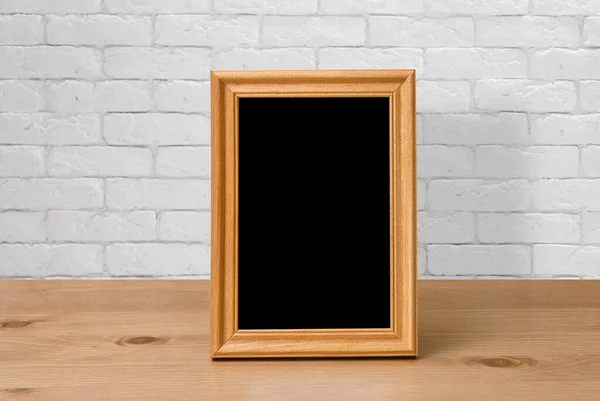 Oud Fotolijstje Houten Tafel Witte Bakstenen Muur — Stockfoto