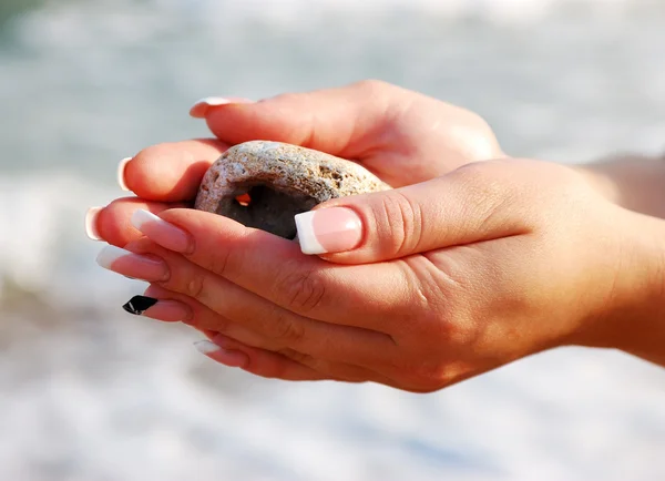 Female hands with sea stones — Stock Photo, Image