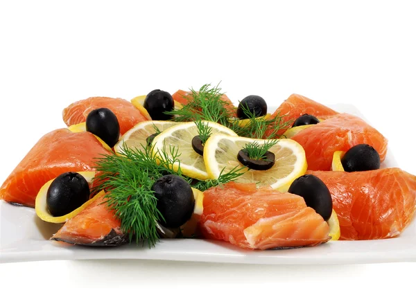 Pieces of salmon with olives and lemon on a plate — Stock Photo, Image