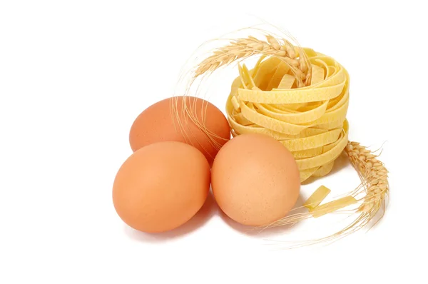 Три курячі яйця, макарони та пшеничні вуха — стокове фото
