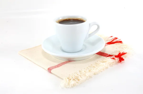 Cup of black coffee on a fabric napkin — Stock Photo, Image