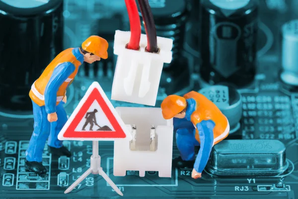 Miniature engineers fixing wire connector — Stock Photo, Image