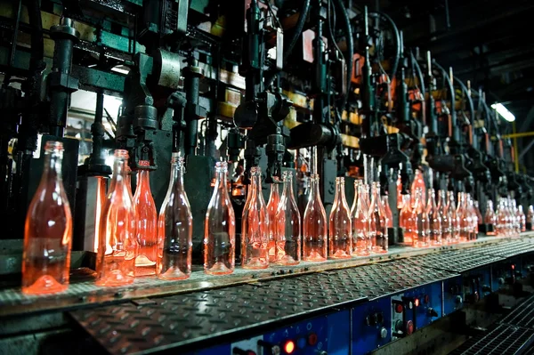 Fábrica de botellas, fila de botellas de vidrio — Foto de Stock