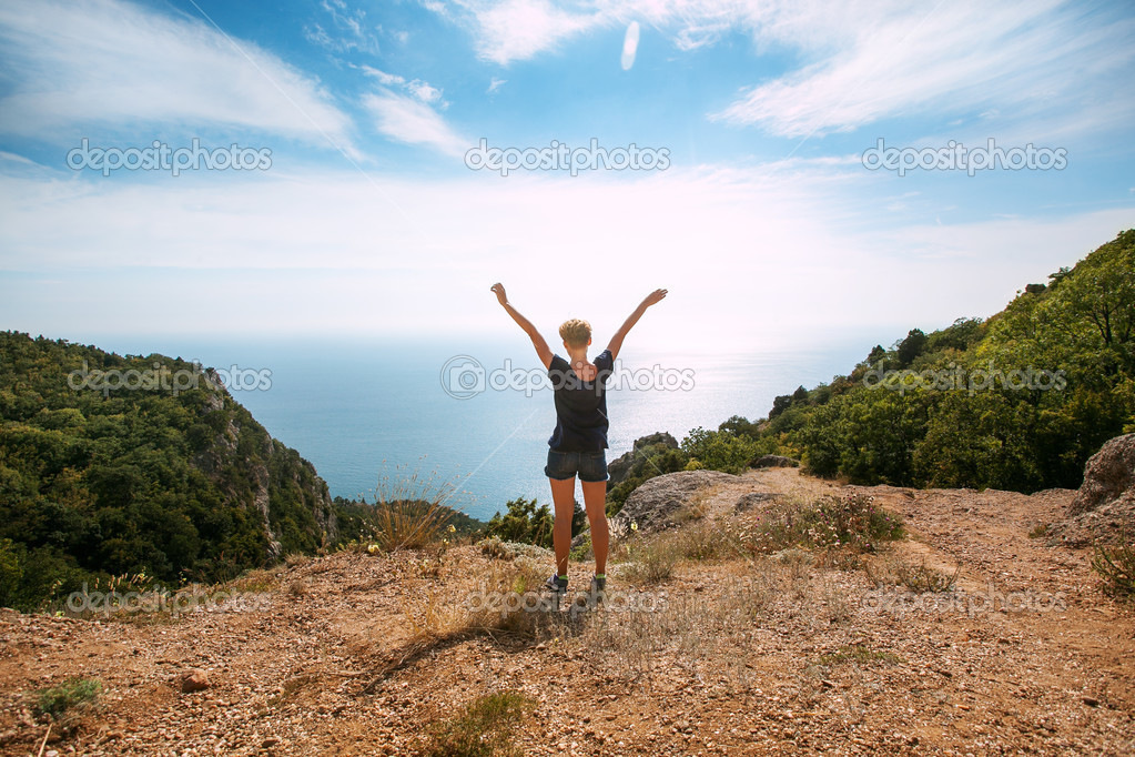 Woman standing On Top Of Mountain