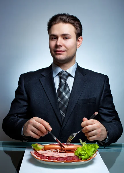 Молодой бизнесмен ест — стоковое фото