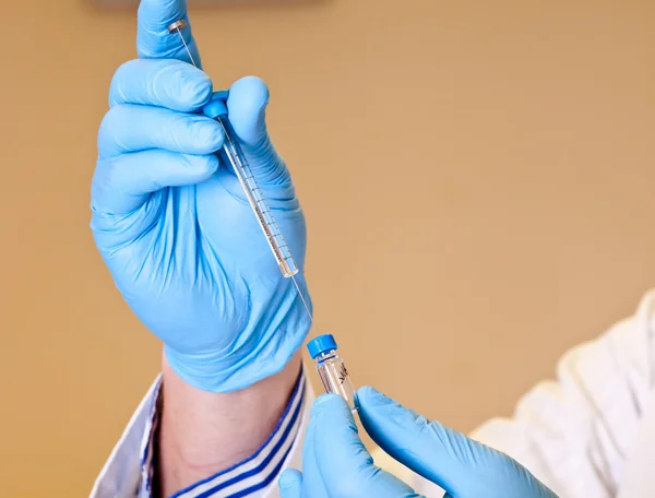 Scienziato tiene siringa per analisi di laboratorio — Foto Stock