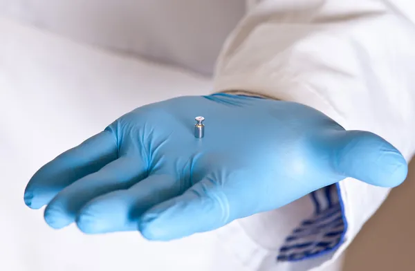 Scientist holds standard weight with tweezers — Stock Photo, Image