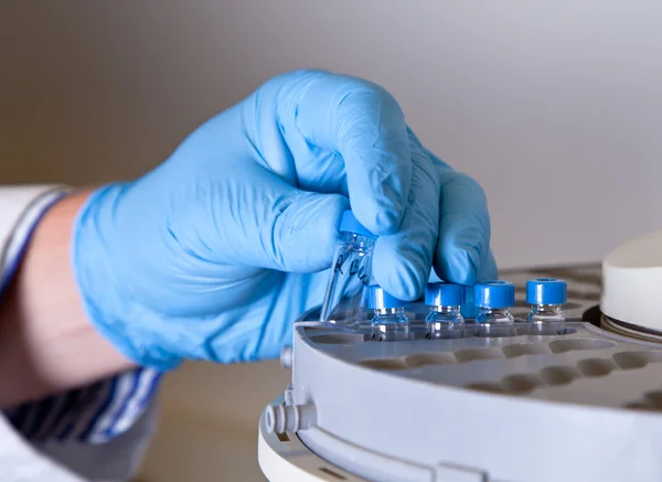 Scientist holds a chemical sample bottle — Stock Photo, Image