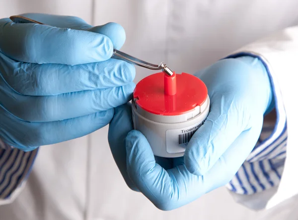 Scientist holds standard weight with tweezers — Stock Photo, Image