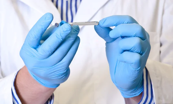 Científico sostiene jeringa para análisis de laboratorio —  Fotos de Stock