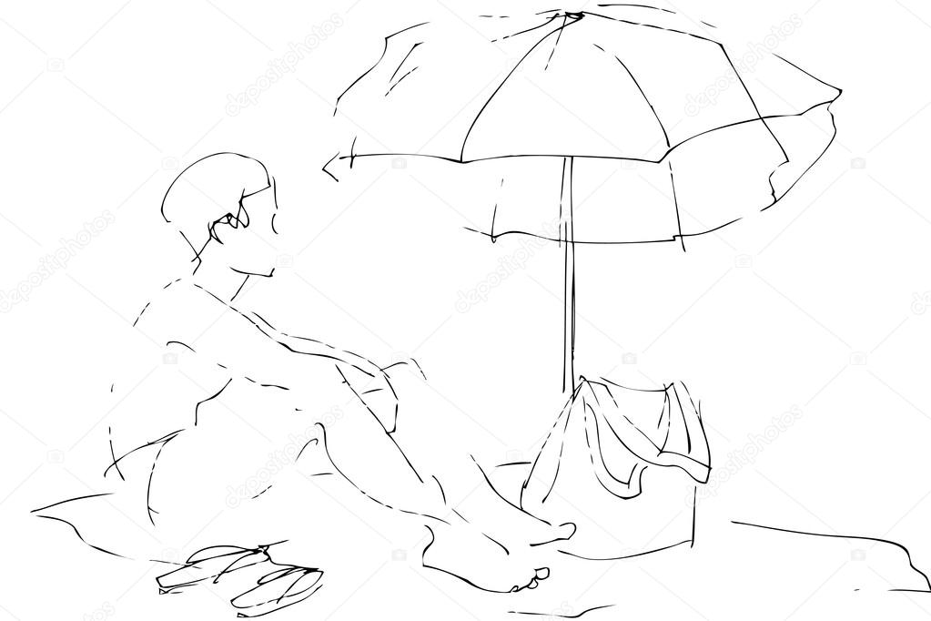 A boy sits on a beach under an umbrella