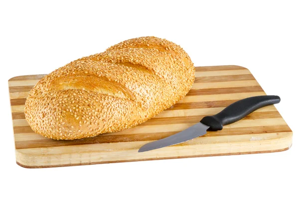 Loaf with sesame seeds on the board and knife — Stock Photo, Image