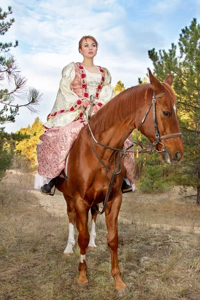 Vacker flicka i antika klänning på hästryggen — Stockfoto