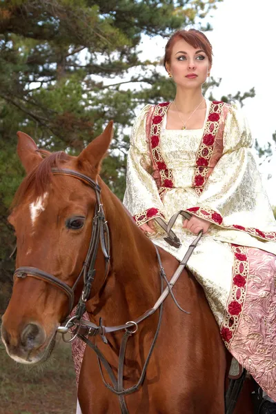 Mooi meisje in antieke jurk op een paard — Stockfoto