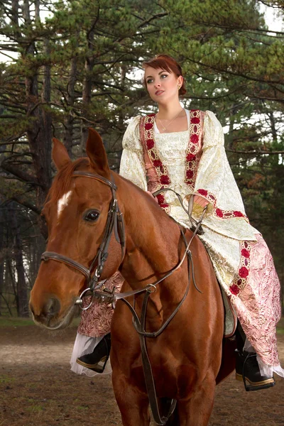 美丽的女孩在古董衣服骑在马背上 — 图库照片