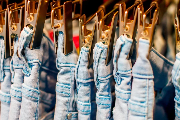 Jeans iron clothespins hanging in the closet — Stock Photo, Image