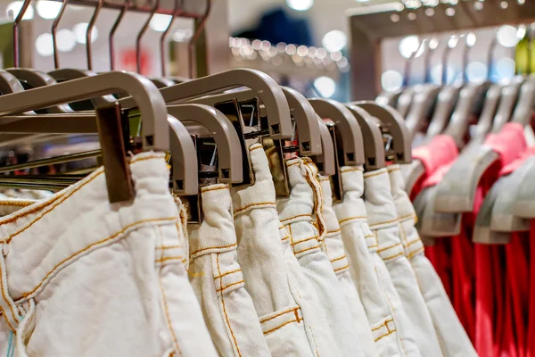 Previsualizar vaqueros colgando de una percha en la tienda — Foto de Stock