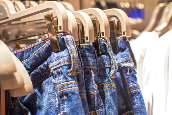 Jeans colgando de una percha en la tienda — Foto de Stock