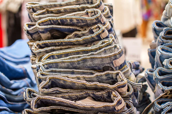 Pila de jeans doblados en la tienda — Foto de Stock