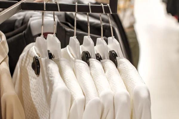 White jackets hanging on a hanger in the store — Stock Photo, Image