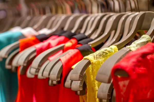 Camisetas colgando de una percha en la tienda — Foto de Stock