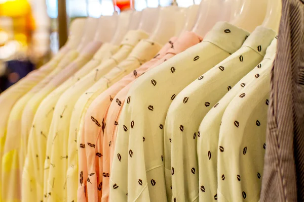 Shirts and jackets hanging on hangers in shop — Stock Photo, Image