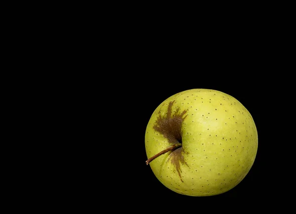 Image of a ripe green apple on a black background