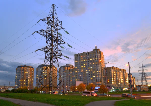 Elektriciteitsleiding voeden de avond stad. — Stockfoto