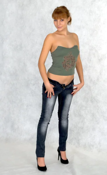 Menina sexy tentando em jeans . — Fotografia de Stock