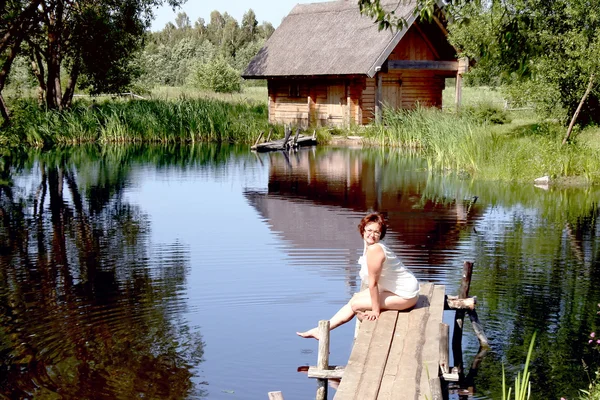 Mulher bonito senta-se em uma ponte — Fotografia de Stock