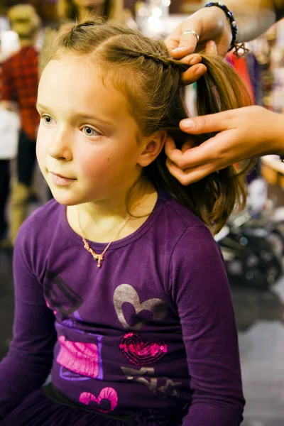 Menina bonito é plait uma trança na moda — Fotografia de Stock