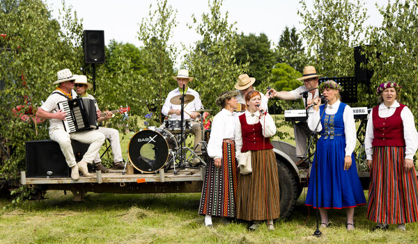 A performance of folk ensemble is in the Latvian national suits