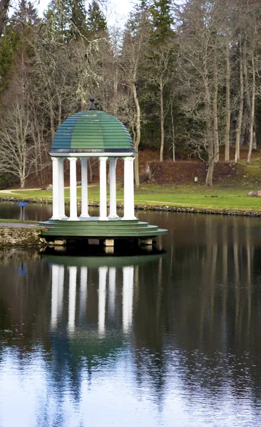 En sommar arbour med vita kolumner är iland sjö — Stockfoto