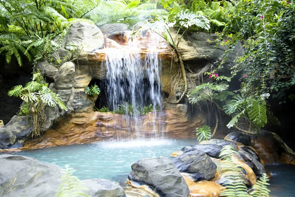 Бассейн с водопадом и горячей термальной водой — стоковое фото