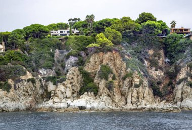 Tossa de Mar 'da Akdeniz kıyısında kozalaklı güzel kayalar popüler Costa Brava, Katalonya, İspanya' da bulunur. Sahildeki inanılmaz kayalık deniz manzarası.