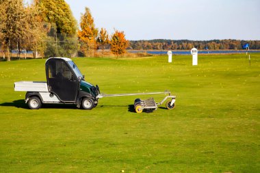LATVIA, RIGA, SEPTEMBER, 2021 - Riga, Letonya 'daki Kisezers gölünün kıyısındaki golf sahasında bir golf topu toplama aracı