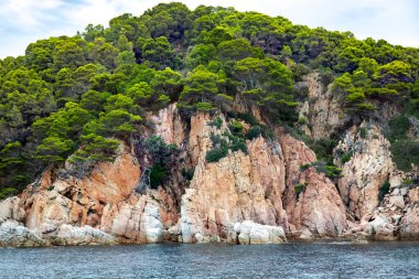 Tossa de Mar 'da Akdeniz kıyısında kozalaklı güzel kayalar popüler Costa Brava, Katalonya, İspanya' da bulunur. Sahildeki inanılmaz kayalık deniz manzarası.
