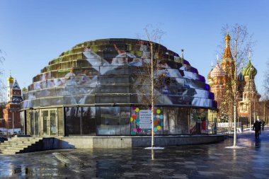 RUSSIA, MOSCOW, Aralık 2021 - Moskova, Rusya 'daki St. Basils Katedrali' nin arka planındaki Zaryadye doğal peyzaj parkındaki bilgi pavyonu kubbesinin görüntüsü