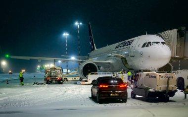 LATVIA, RIGA, ARALIK, 2021 - Lufthansa uçağı kış sabahının erken saatlerinde uçmaya ve Riga Uluslararası Havaalanı 'nda bagajları yüklemeye hazırlanıyor. Letonya