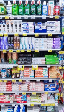 Letonya, Riga, Şubat 2022 - Alışveriş merkezindeki raflarda diş macunları, diş durulama ve ağız bakım ürünlerinden oluşan geniş bir seçim.