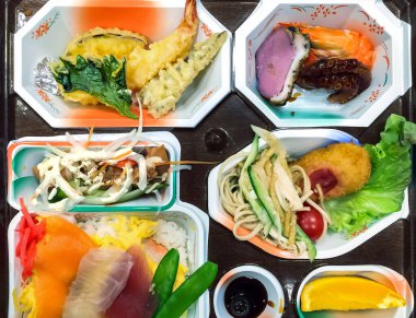 Çeşitli dengeli yemeklerle geleneksel Japon yemeği. Sağlıklı beslenme, yemek hazırlama. Pirinç, karides, ahtapot, ton balığı tataki, tamago ve sebze..